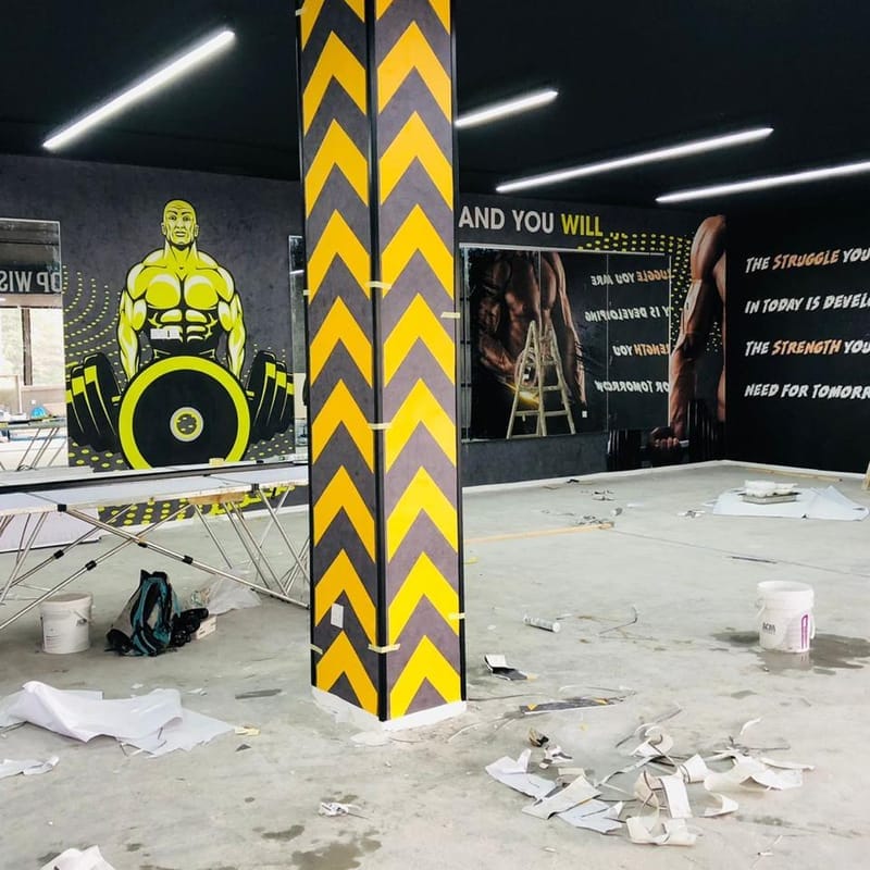 Gym wall and column wrap installation with weightlifter illustration and motivational quotes