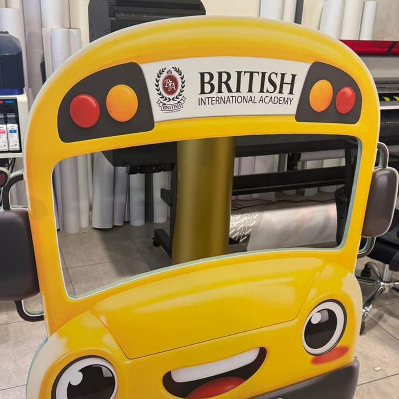 Yellow cartoon school bus photo frame cutout branded for British International Academy