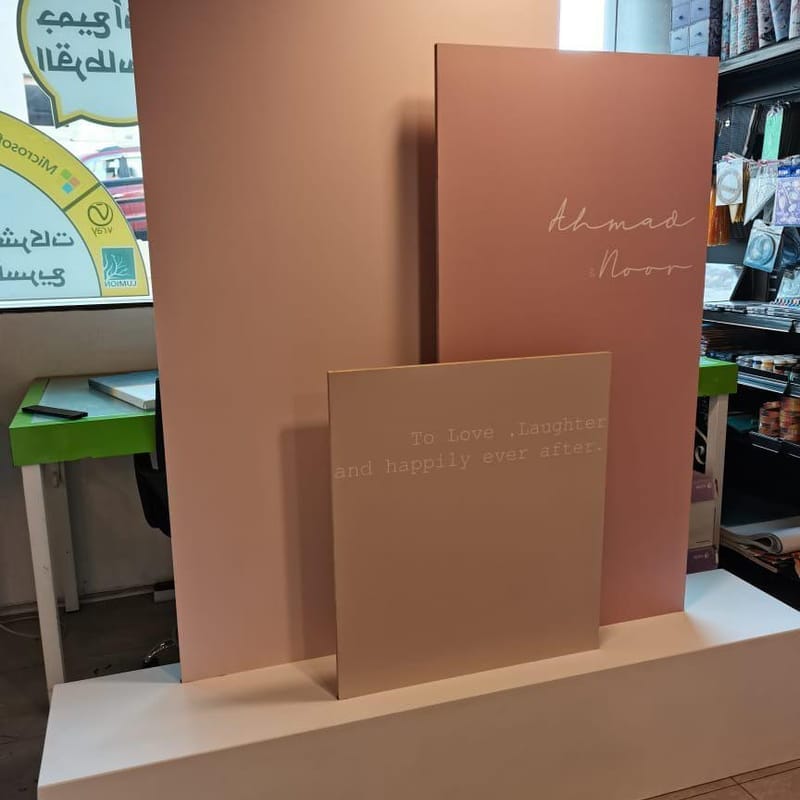 Layered blush pink display boards with the names Ahmad and Noor and a love quote for a wedding