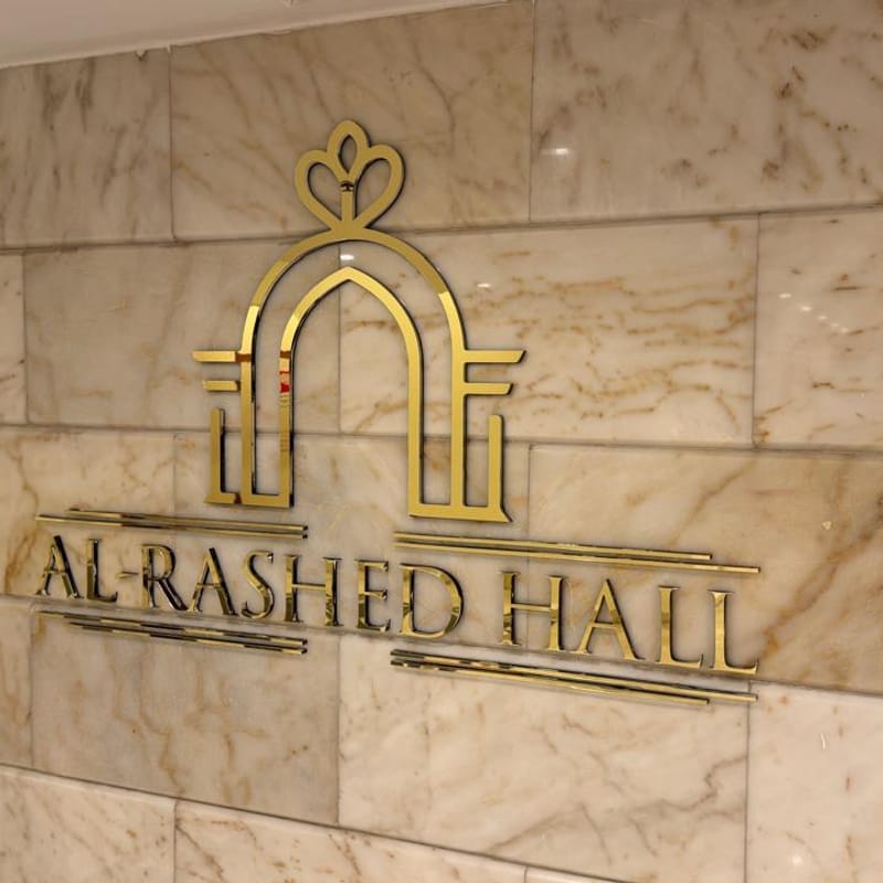 Premium gold dimensional lettering and logo signage for Al Rashed Hall event venue on marble wall
