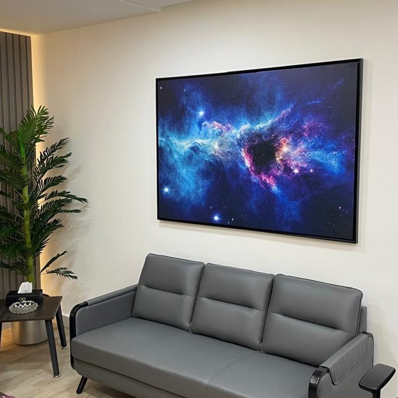 Stunning large-format framed canvas print of a galaxy nebula displayed in modern office setting